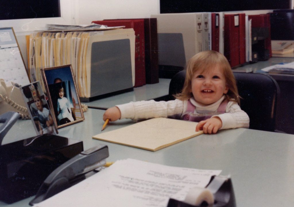 Young Julia sitting at her father's desk, ready to work.